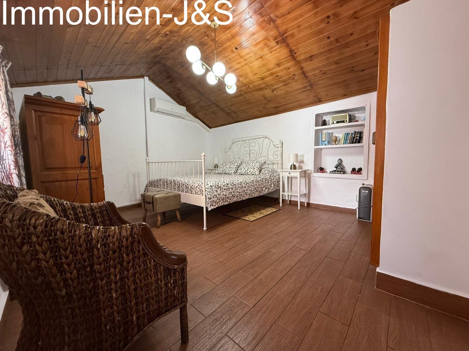 Großzügiges Hauptschlafzimmer mit Klimaanlage und gemütlicher Leseecke