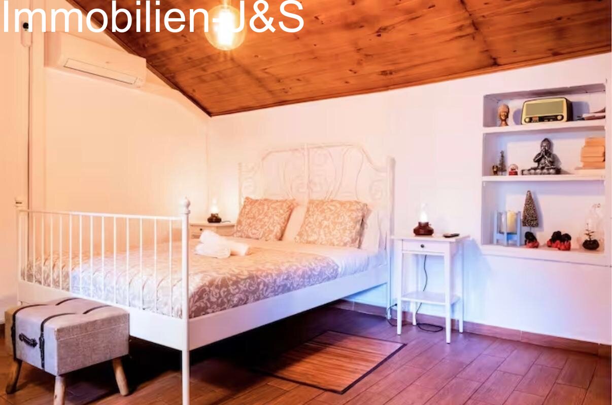 Einladendes Schlafzimmer mit stilvollem Metallbett und Einbauregalen.