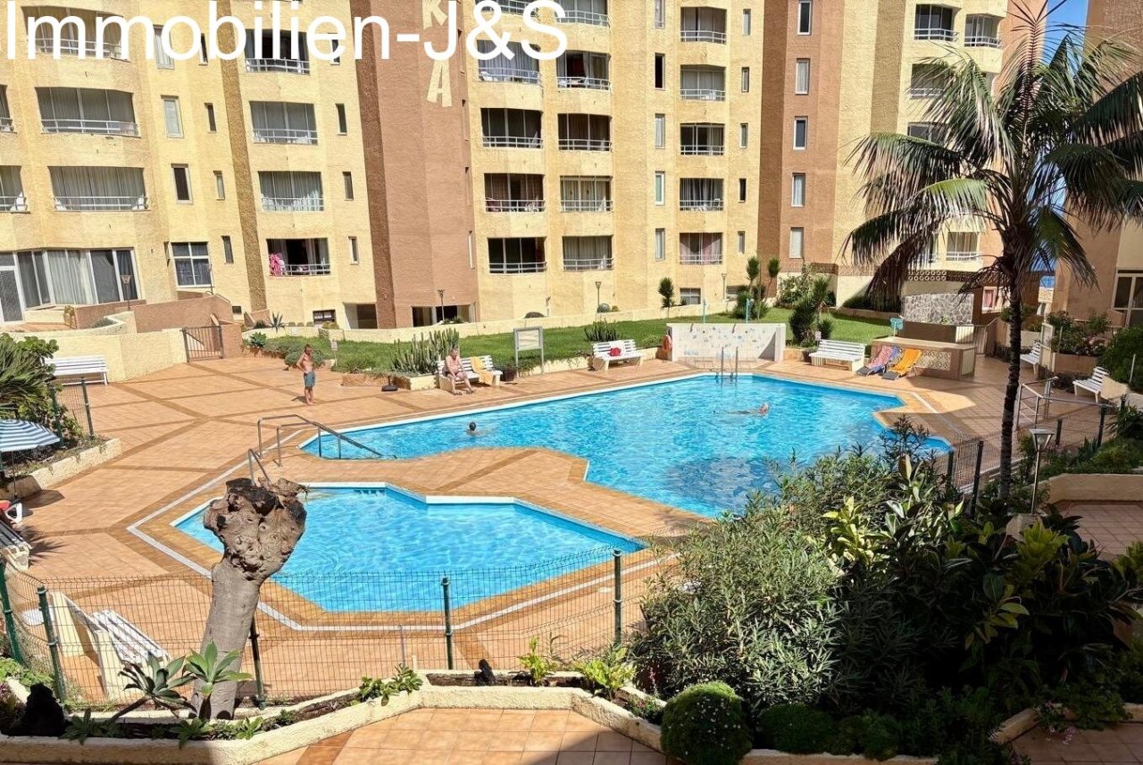 Blick auf die großzügige Poollandschaft der Anlage Sibora, eingebettet in die markante Architektur und gepflegte Gemeinschaftsbereiche.