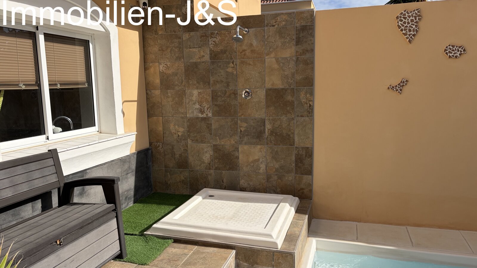Moderner Außenbereich mit einem privaten Pool, einer stilvoll gefliesten Außendusche und einer dekorativen Wandgestaltung, die die Silhouette der Kanarischen Inseln zeigt. Eine gemütliche Sitzbank lädt zum Verweilen ein. Moderner Außenbereich mit einem privaten Pool, einer stilvoll gefliesten Außendusche und einer dekorativen Wandgestaltung, die die Silhouette der Kanarischen Inseln zeigt. Eine gemütliche Sitzbank lädt zum Verweilen ein.