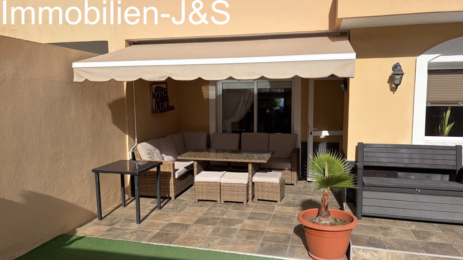 Einladende, überdachte Terrasse mit komfortablen Rattan-Loungemöbeln und einer Markise für entspannte Stunden im Freien. Einladende, überdachte Terrasse mit komfortablen Rattan-Loungemöbeln und einer Markise für entspannte Stunden im Freien.