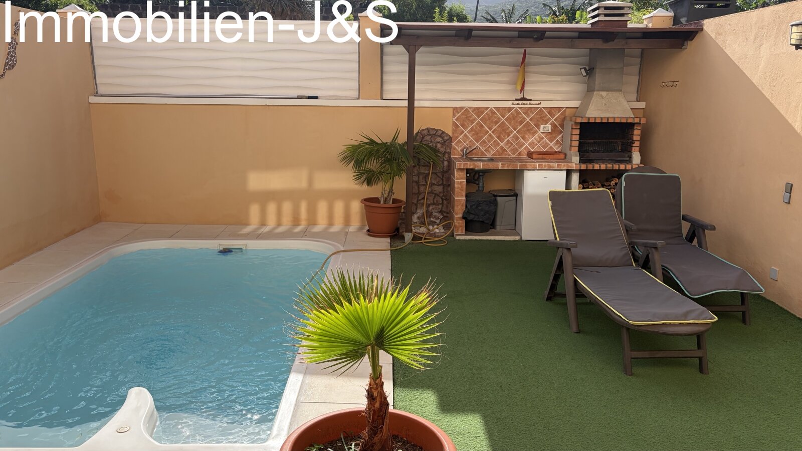 Moderner Außenbereich mit einem privaten Pool, einer stilvoll gefliesten Außendusche und einer dekorativen Wandgestaltung, die die Silhouette der Kanarischen Inseln zeigt. Eine gemütliche Sitzbank lädt zum Verweilen ein. Moderner Außenbereich mit einem privaten Pool, einer stilvoll gefliesten Außendusche und einer dekorativen Wandgestaltung, die die Silhouette der Kanarischen Inseln zeigt. Eine gemütliche Sitzbank lädt zum Verweilen ein.