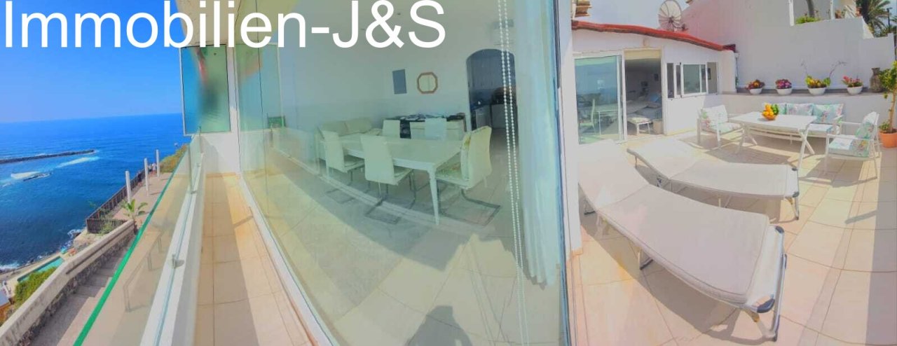 Offenes Wohn- und Esszimmer mit großen Glasfronten, die einen nahtlosen Übergang zur privaten Sonnenterrasse und dem Meerblick schaffen.