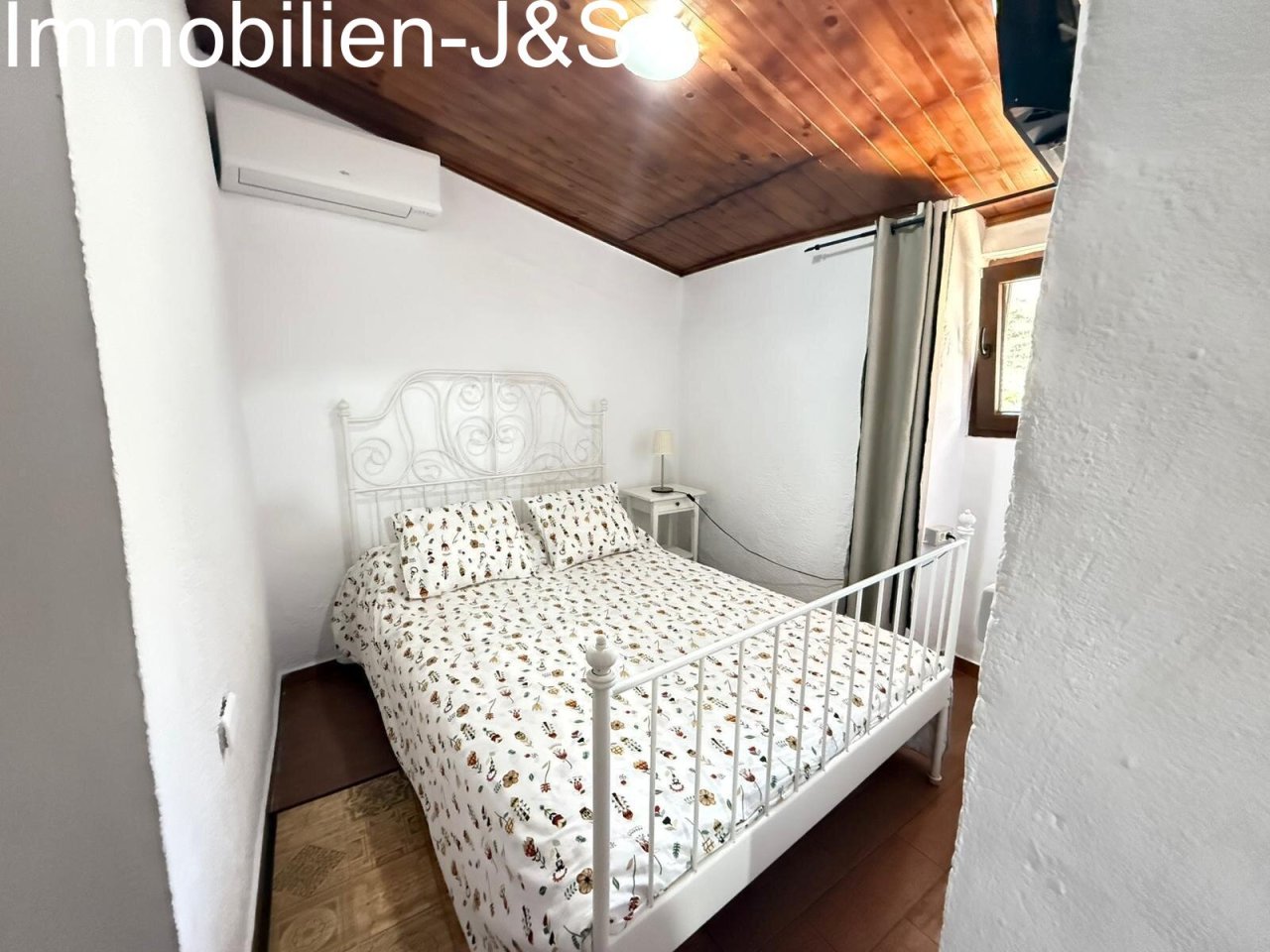 Brightly designed guest room with traditional wooden ceiling