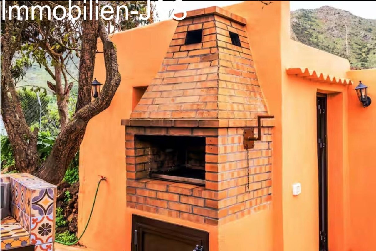 Outdoor kitchen with mosaic details and a built-in BBQ in the garden.