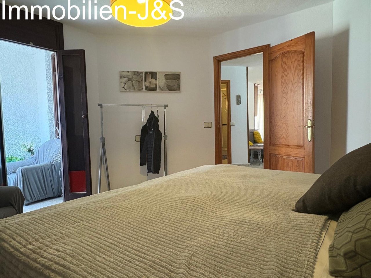 The spacious master bedroom features plenty of natural light, a cozy atmosphere with classic wooden furniture, and offers ample space for relaxation.