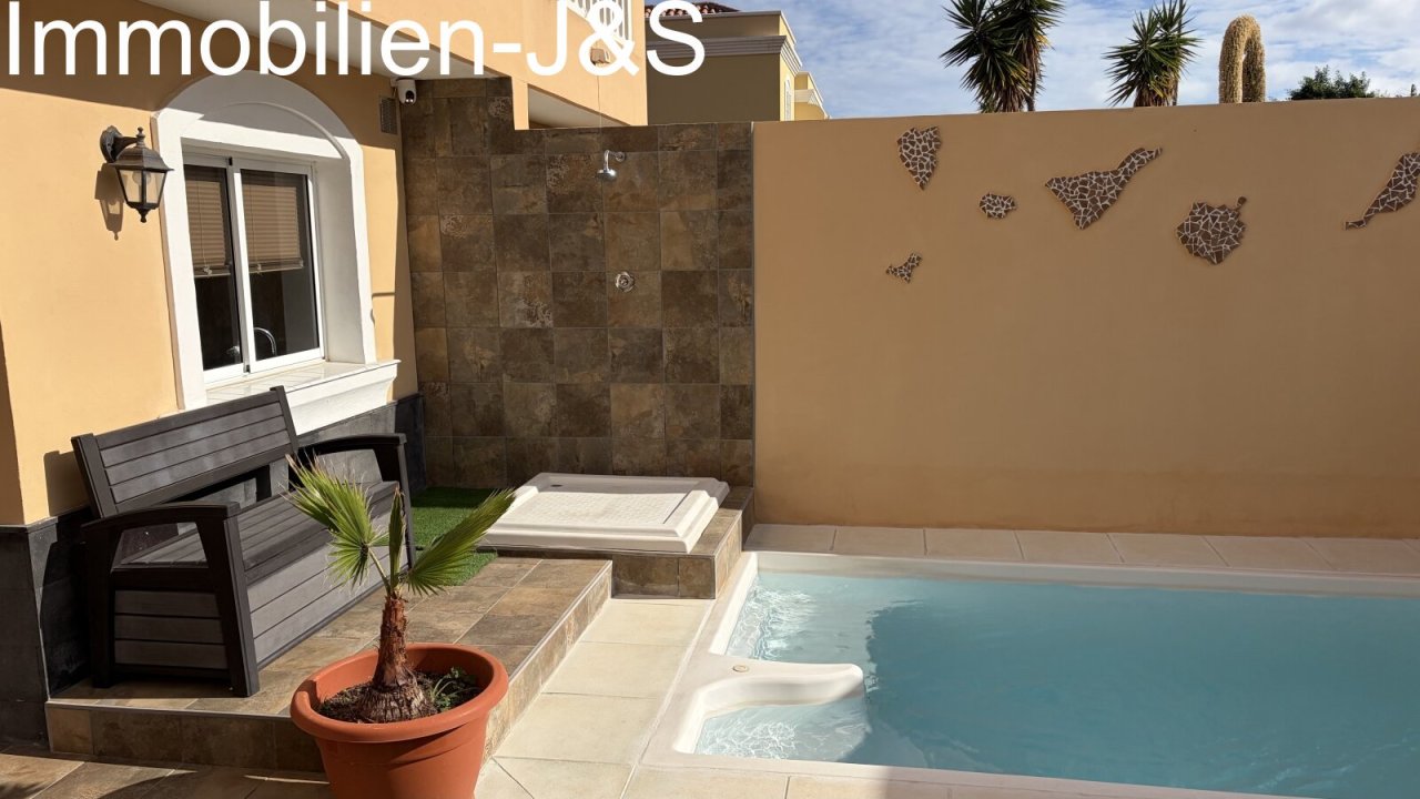 Modern outdoor area featuring a private pool, a stylishly tiled outdoor shower, and decorative wall art depicting the silhouette of the Canary Islands. A comfortable bench provides a perfect spot to relax. Modern outdoor area featuring a private pool, a stylishly tiled outdoor shower, and decorative wall art depicting the silhouette of the Canary Islands. A comfortable bench provides a perfect spot to relax.