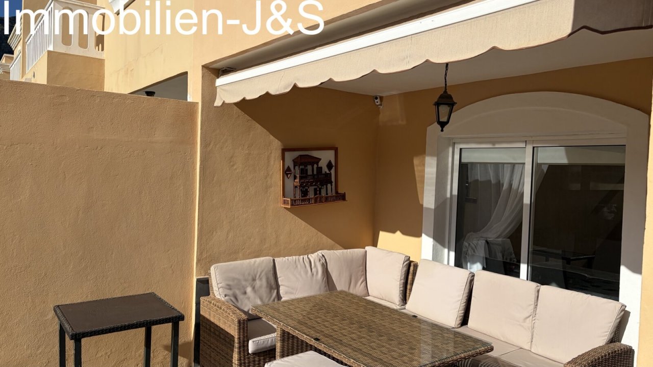 Inviting covered terrace with comfortable rattan lounge furniture and an awning for relaxing hours outdoors. Inviting covered terrace with comfortable rattan lounge furniture and an awning for relaxing hours outdoors.
