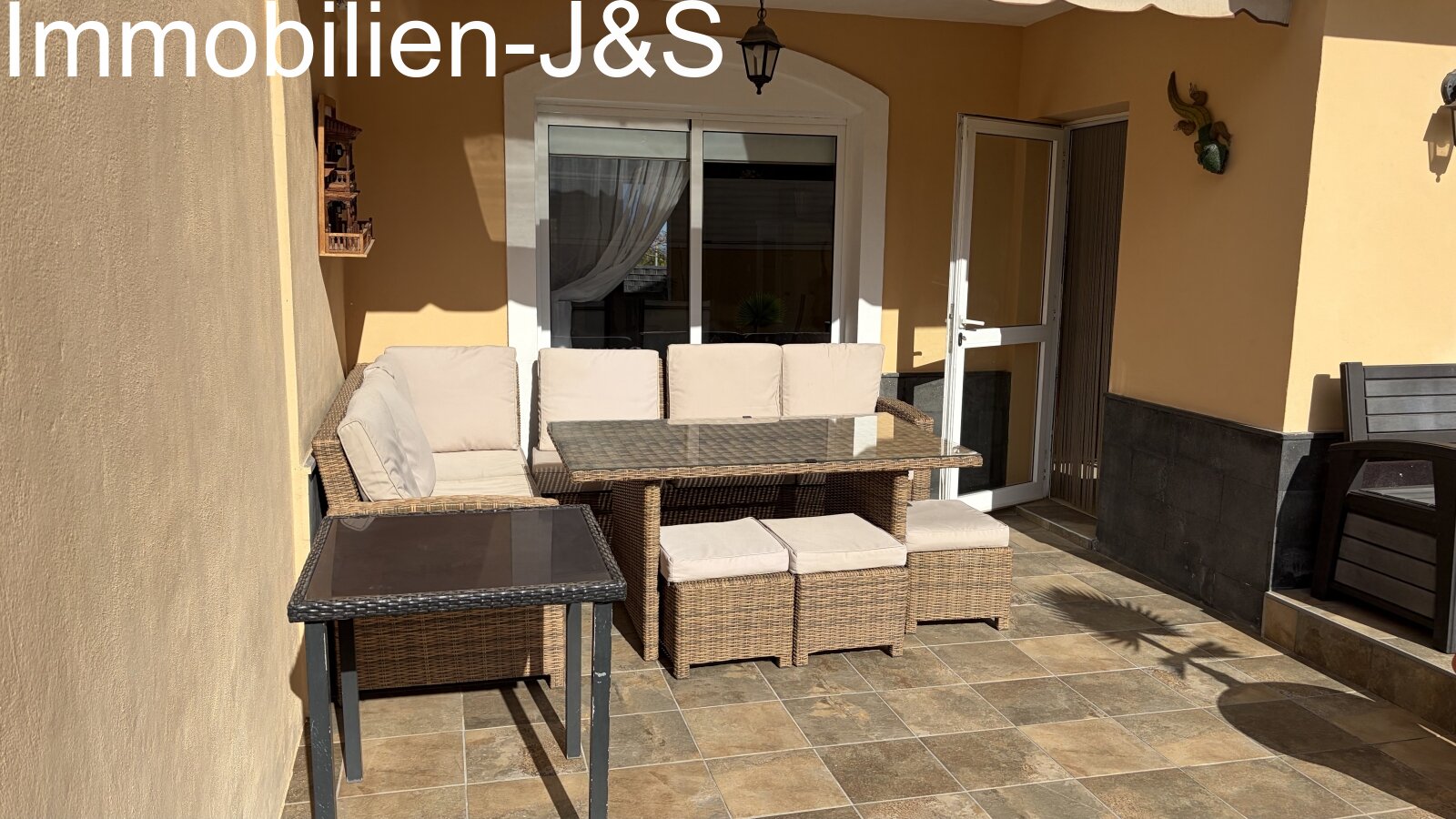 Inviting covered terrace with comfortable rattan lounge furniture and an awning for relaxing hours outdoors. Inviting covered terrace with comfortable rattan lounge furniture and an awning for relaxing hours outdoors.