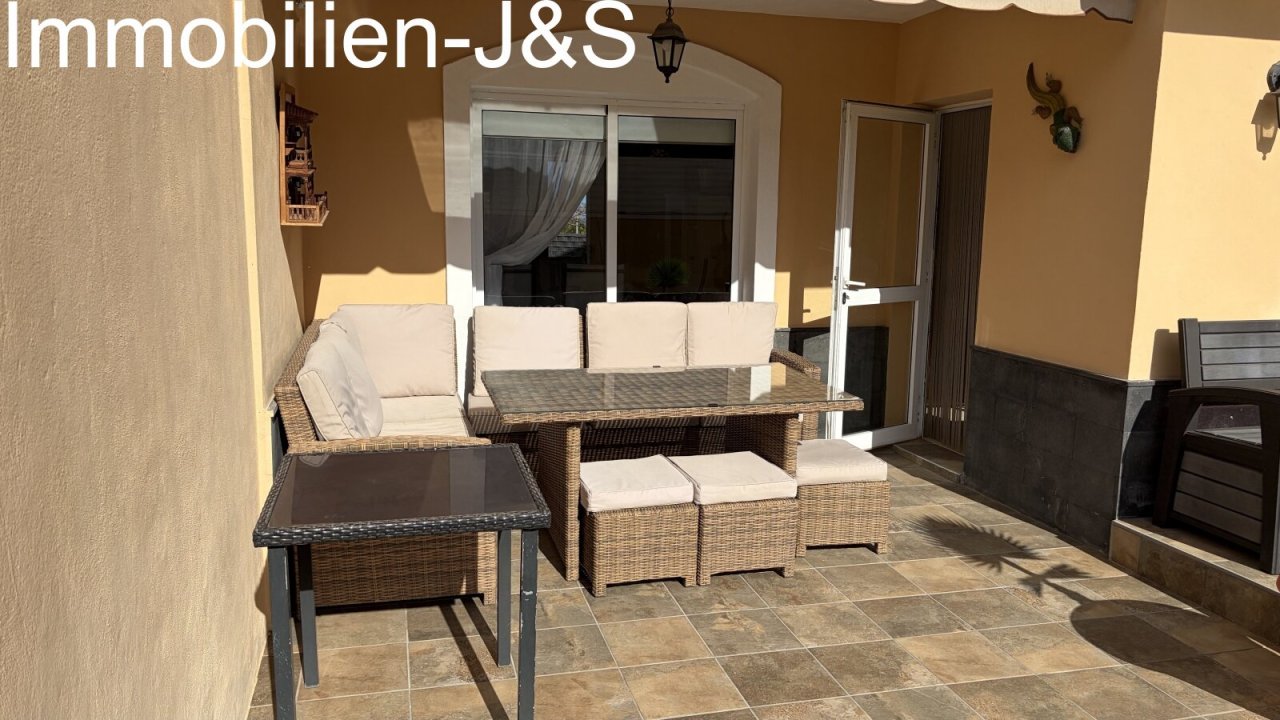 Inviting covered terrace with comfortable rattan lounge furniture and an awning for relaxing hours outdoors. Inviting covered terrace with comfortable rattan lounge furniture and an awning for relaxing hours outdoors.