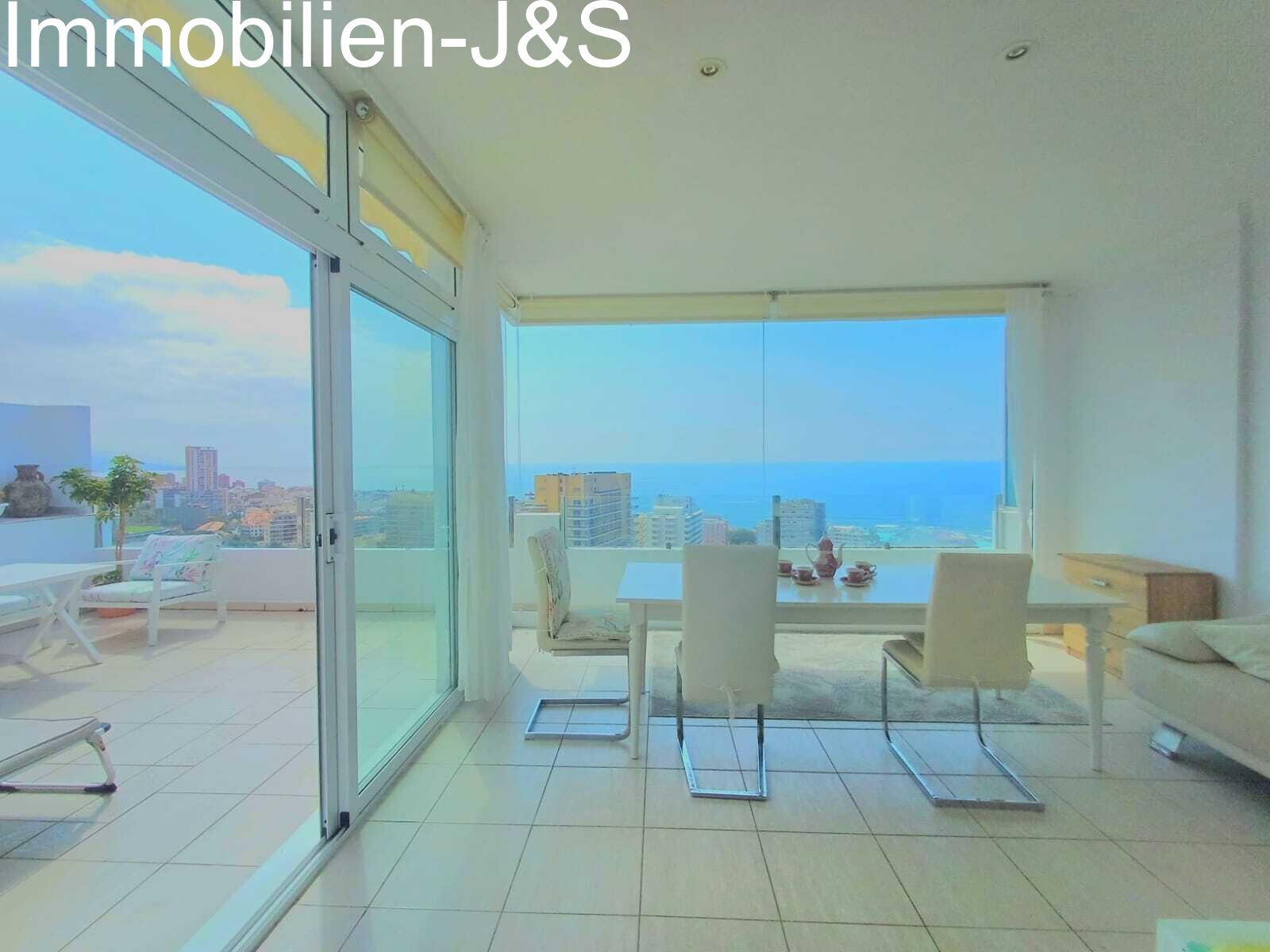 Light-filled interior with floor-to-ceiling glass fronts overlooking the city of Puerto de la Cruz and the ocean.