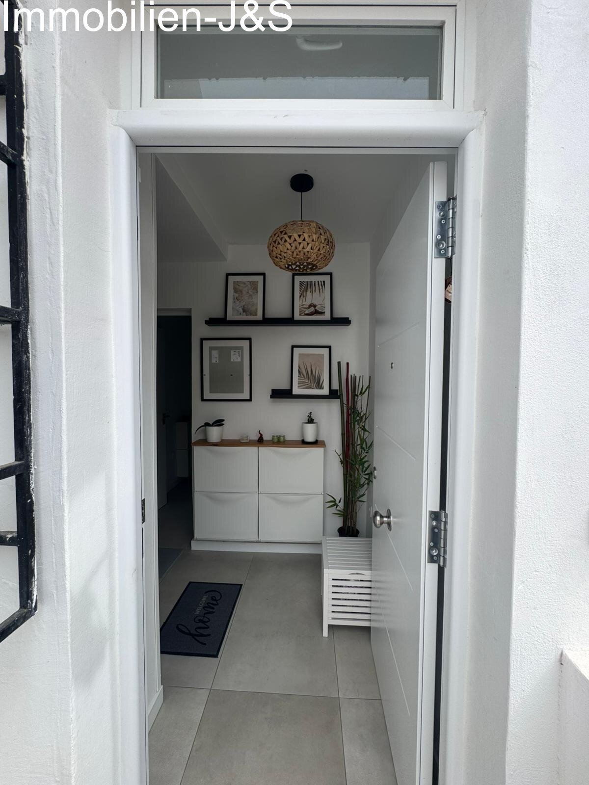 A bright and friendly entrance area that immediately creates a sense of home. The hallway connects the rooms efficiently and offers discreet storage with elegant white built-in wardrobes. The minimalist design and light floor tiles emphasize the modern ambiance of the entire property.