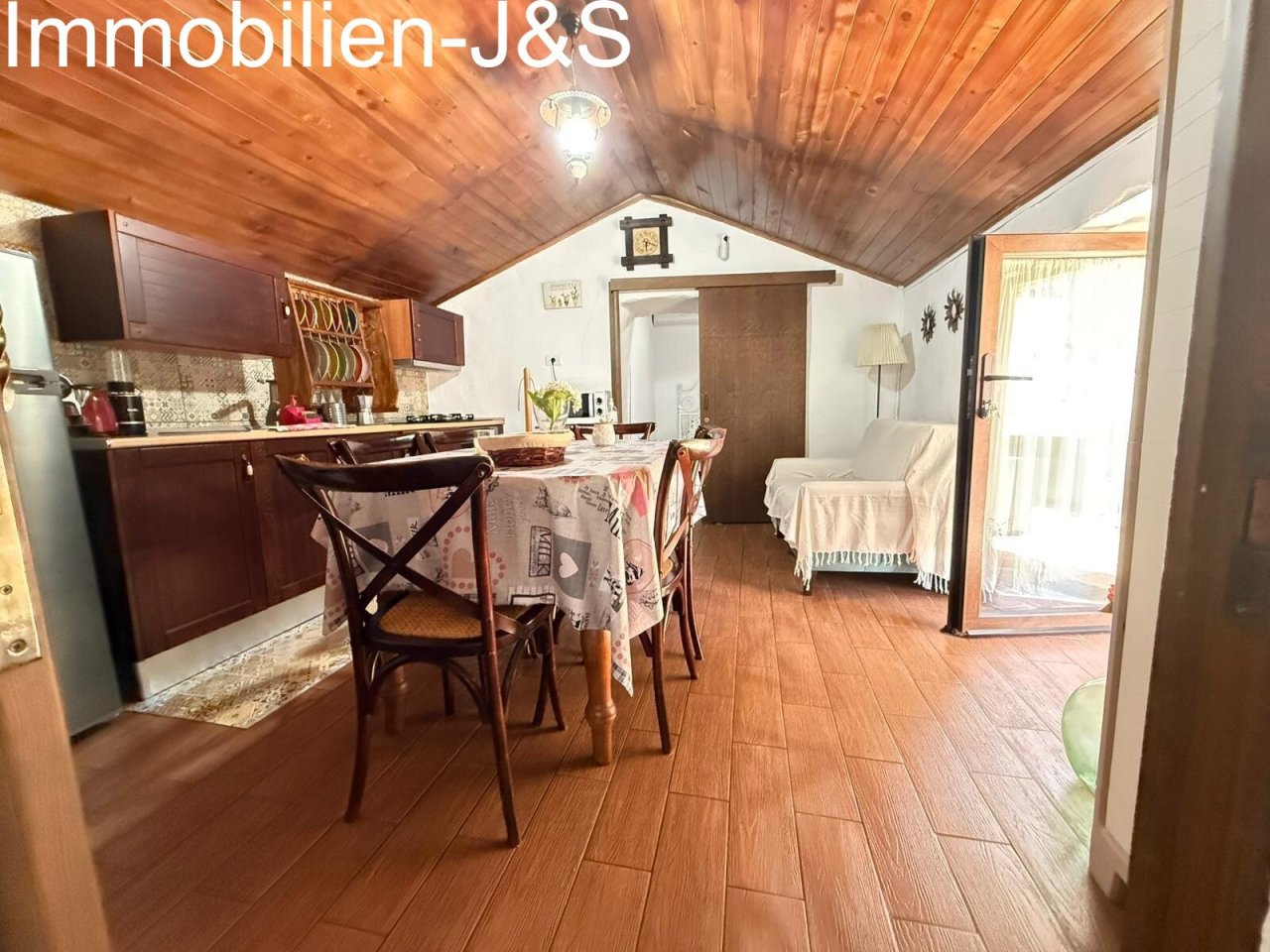 Salón-comedor diáfano con cocina rústica integrada