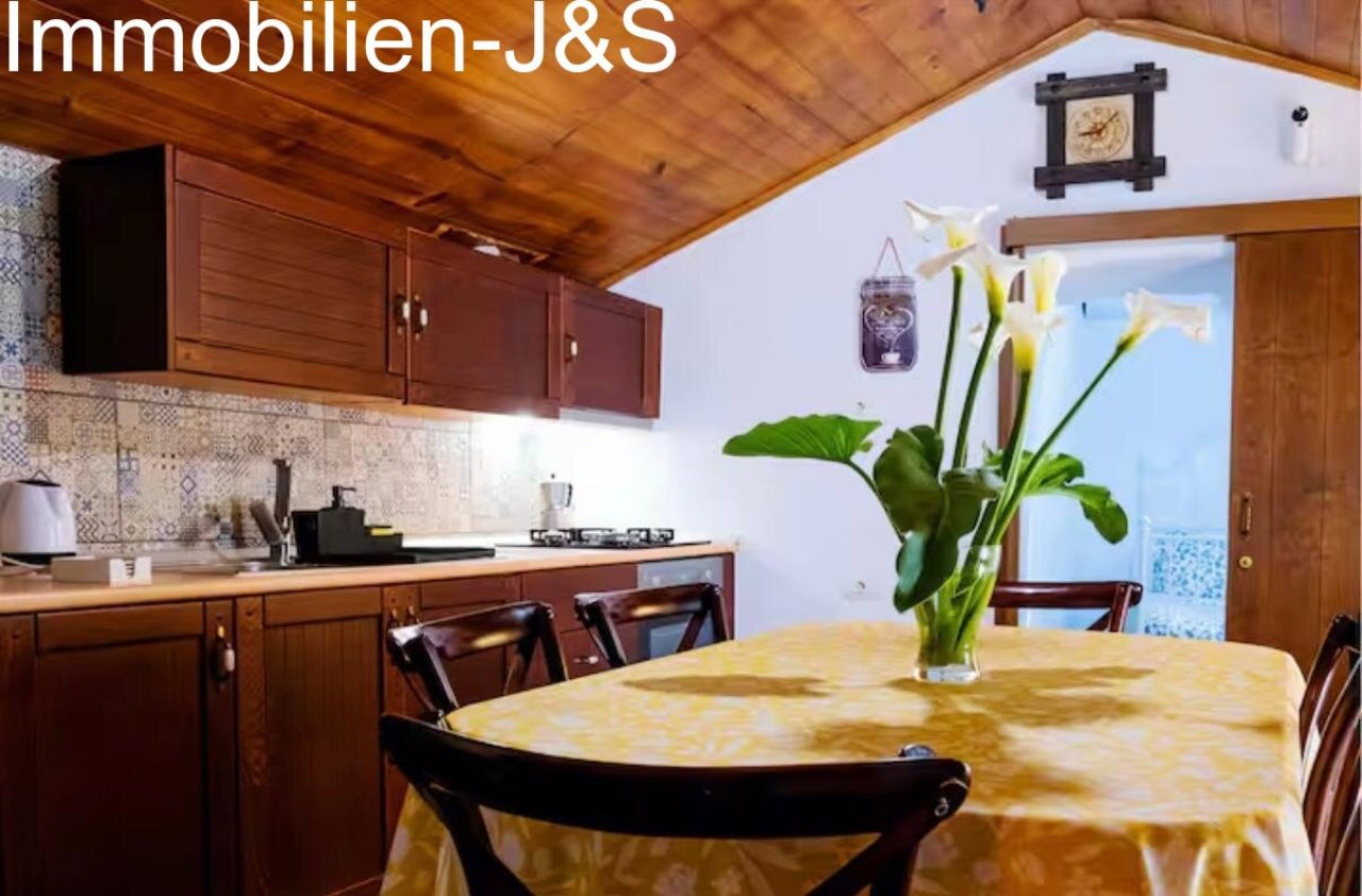 Cocina de estilo rural totalmente equipada con zona de comedor integrada.