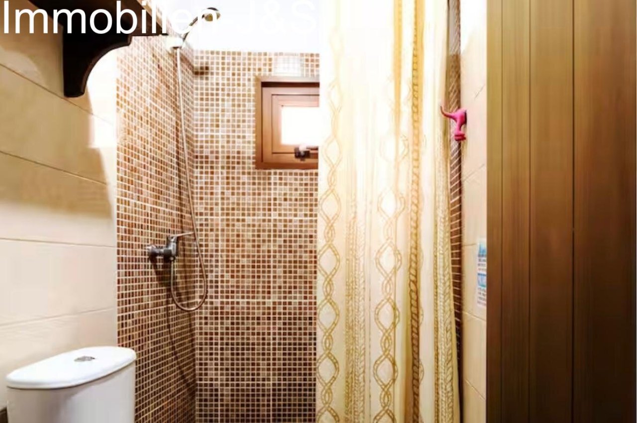 Baño moderno con elementos de bloques de vidrio y ducha de efecto lluvia