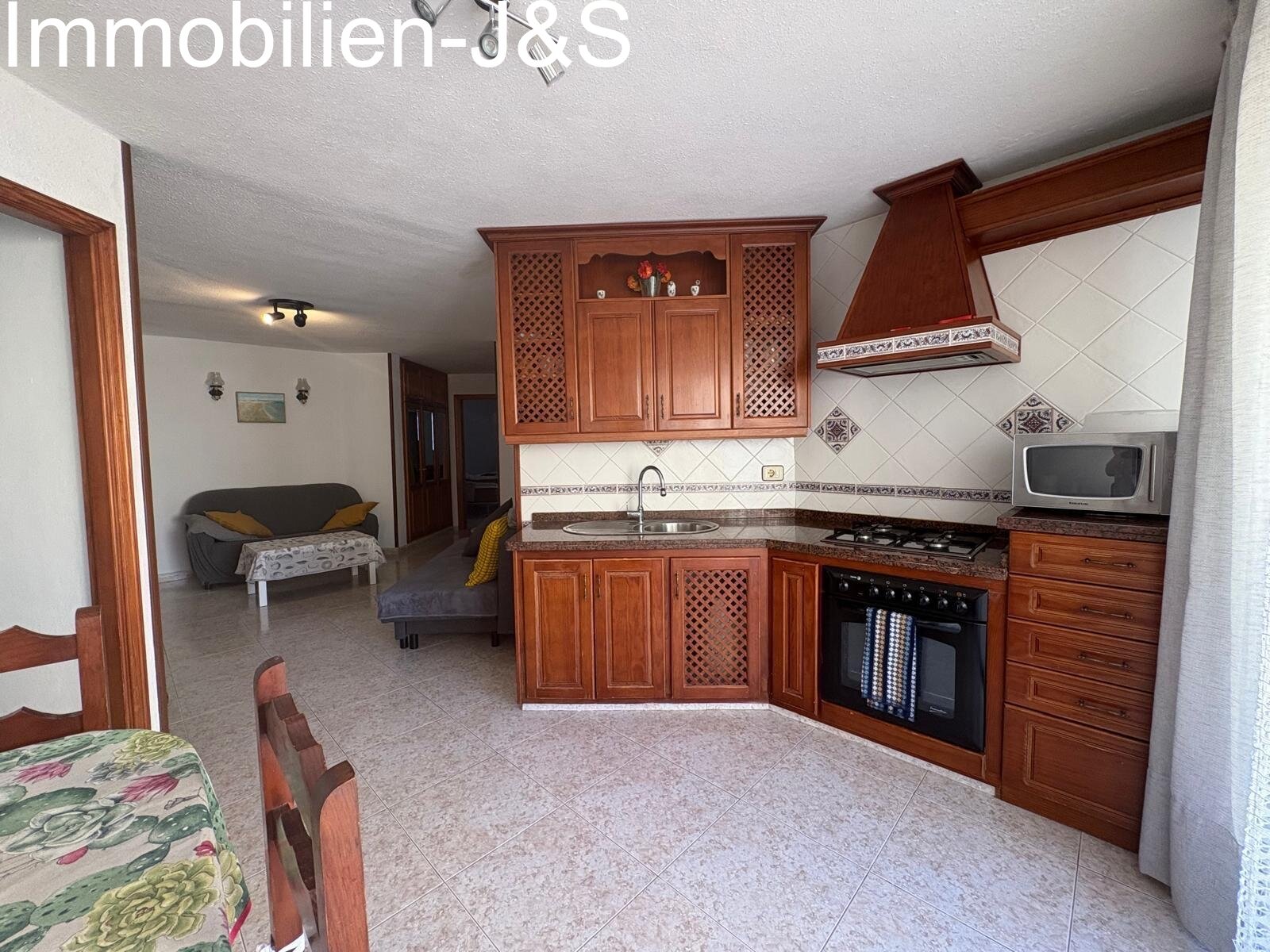 Encantadora zona de cocina de estilo tradicional canario con frontales de madera maciza de alta calidad, detalles integrados y una transición fluida hacia el comedor y el salón.